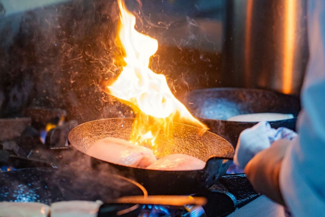 Chef cooking in a pan with flames